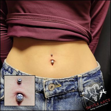 Bauchnabelpiercing mit silbernem Bauchnabelstecker und zwei Kristallen.