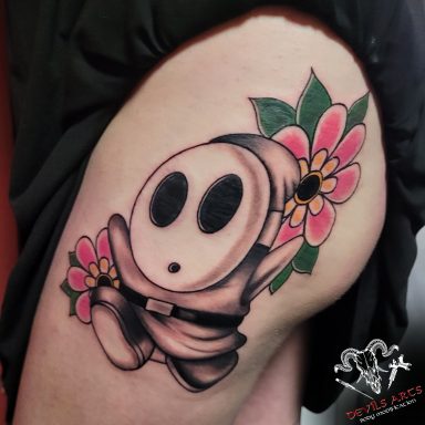 Shy Guy Black & Grey / Oldschool Tattoo Shy Guy Tattoo im Black & Grey Stil mit bunten Oldschool-Blüten am oberen Oberschenkel von DEVILS-ARTS Emmelshausen