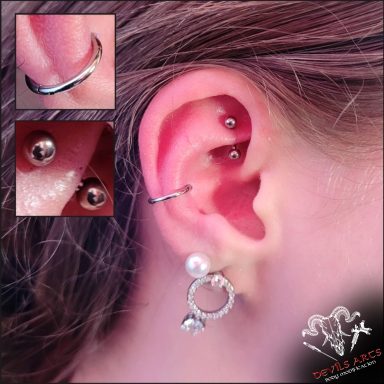 Inner-Conch-Piercing mit silbernem Segmentring-Clicker und Rook-Piercing mit silbernem Bananabell.