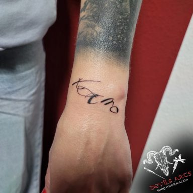 Schriftzug-Tattoo „Karma“ am Handgelenk, nach handgezeichneter Vorlage der Kundin umgesetzt.