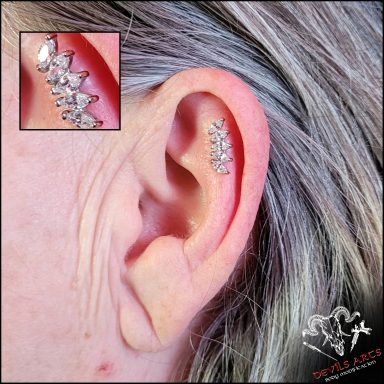 Outer-Conch-Piercing mit silbernem 5-Kristall-Stecker am Ohr.
