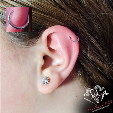 Helix-Piercing mit Segmentring-Clicker am Ohr.