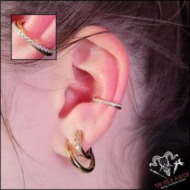 Innerconch-Piercing mit goldenem Kristall-Clicker am Ohr.