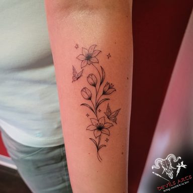 Fineline Blumen- & Schmetterlings-Tattoo Fineline Blumen- und Schmetterlings-Tattoo mit feinen floralen Details auf dem Unterarm bei DEVILS-ARTS in Emmelshausen